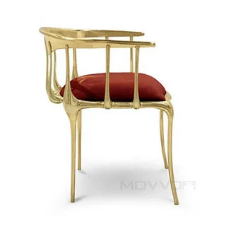 Gold accent chair with red velvet cushion and open back