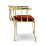 Gold accent chair with red velvet cushion and open back